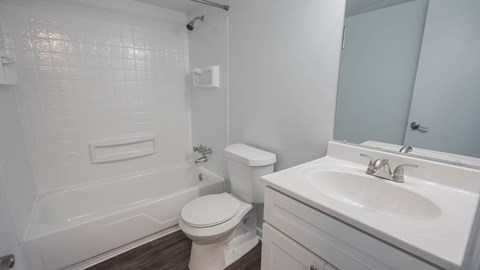 A white bathroom with a toilet, sink, and bathtub.