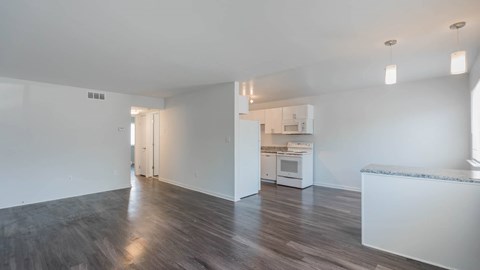 Unfurnished living room with wood-style flooring and a view into the kitchen at Jefferson Flats.