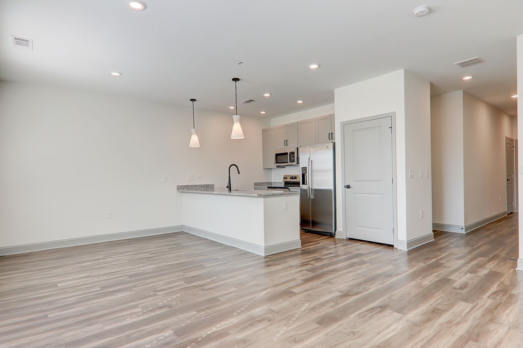 A kitchen with a refrigerator, sink, and cabinets.