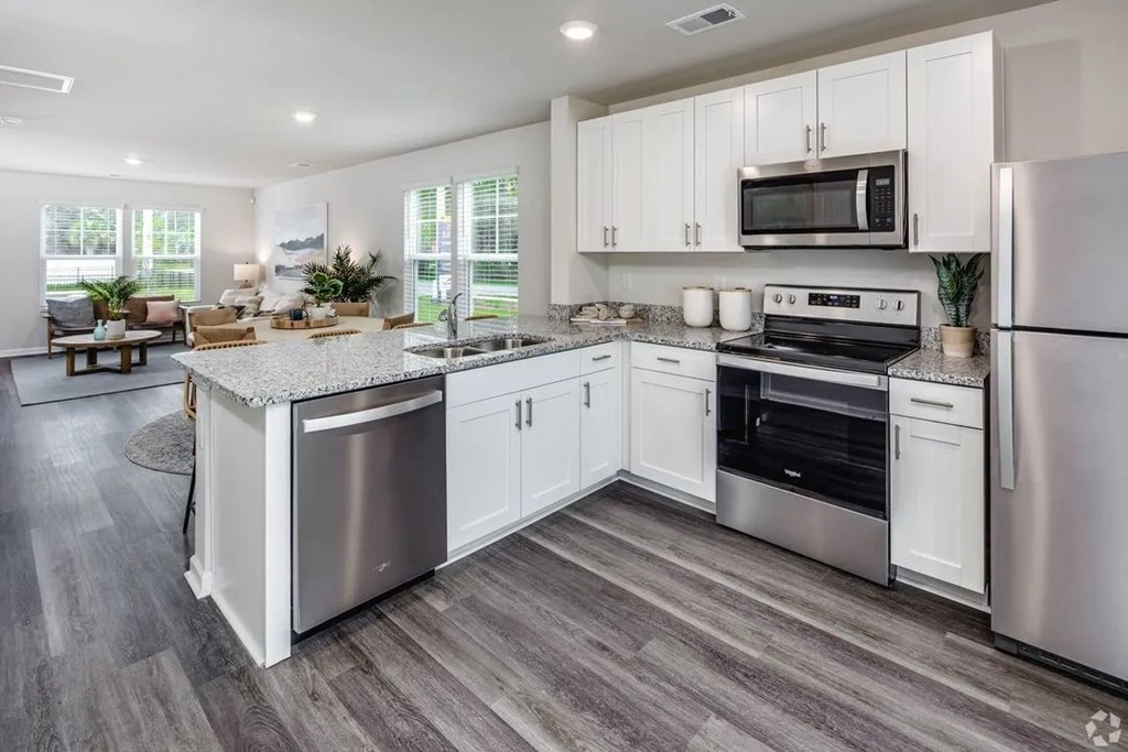 A modern kitchen with stainless steel appliances and white cabinetry.