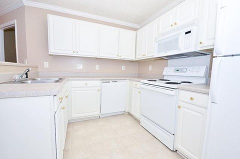 A kitchen with white appliances and cabinets.