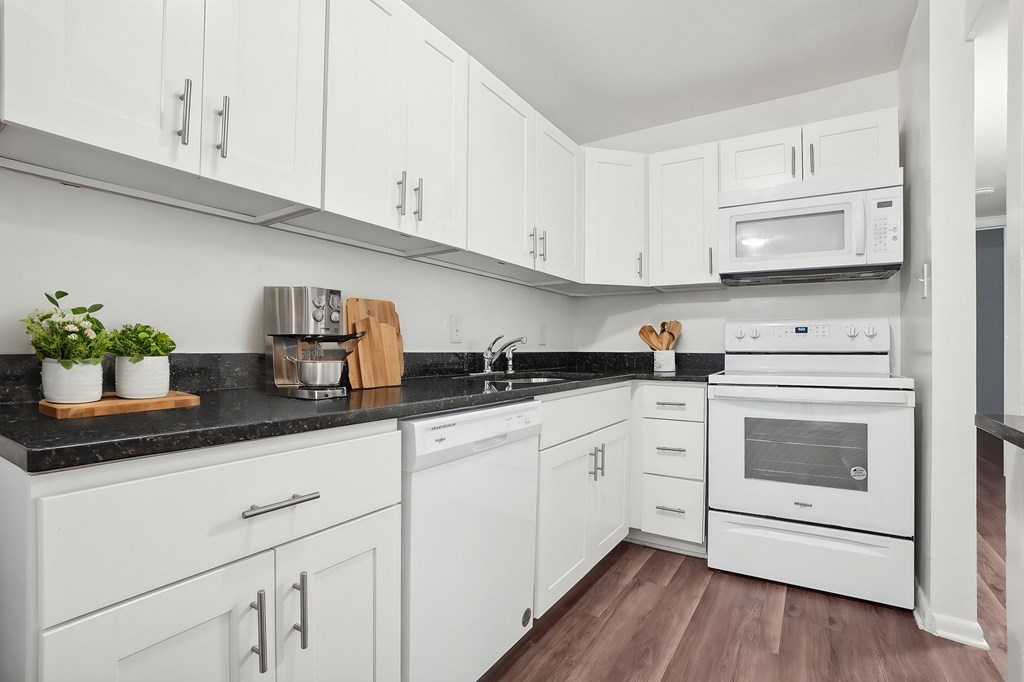 A kitchen with white cabinets and appliances.