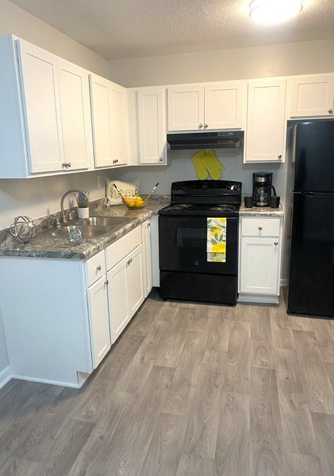 a renovated kitchen with white cabinets and black appliances