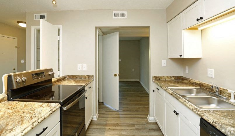 a kitchen with white cabinets and granite counter tops