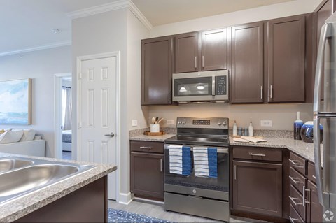 A kitchen with brown cabinets and stainless steel appliances.