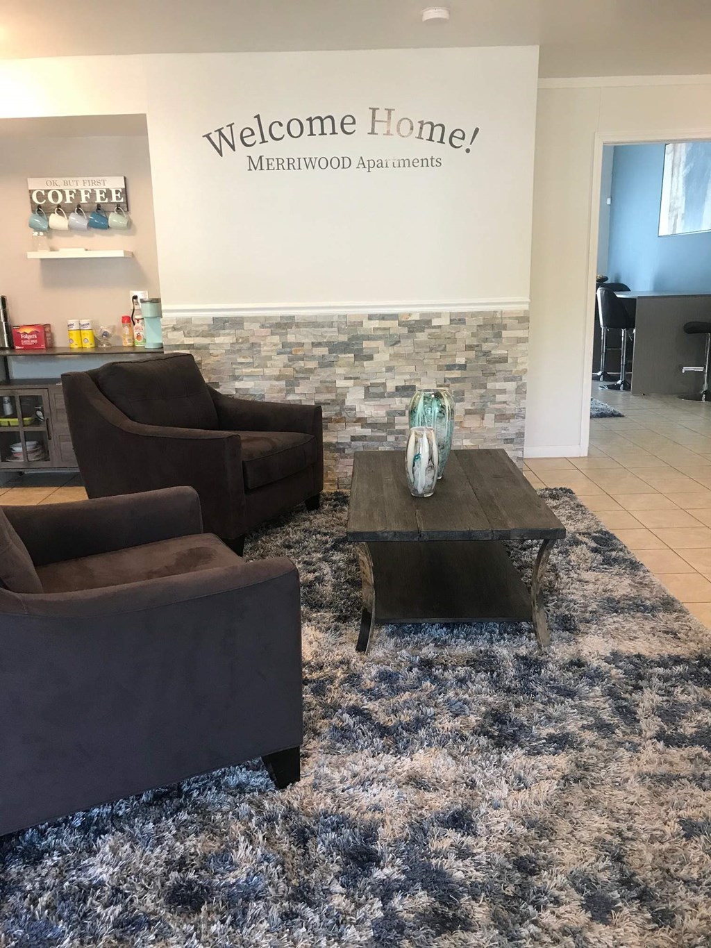 a living room with couches and a coffee table in front of a brick wall