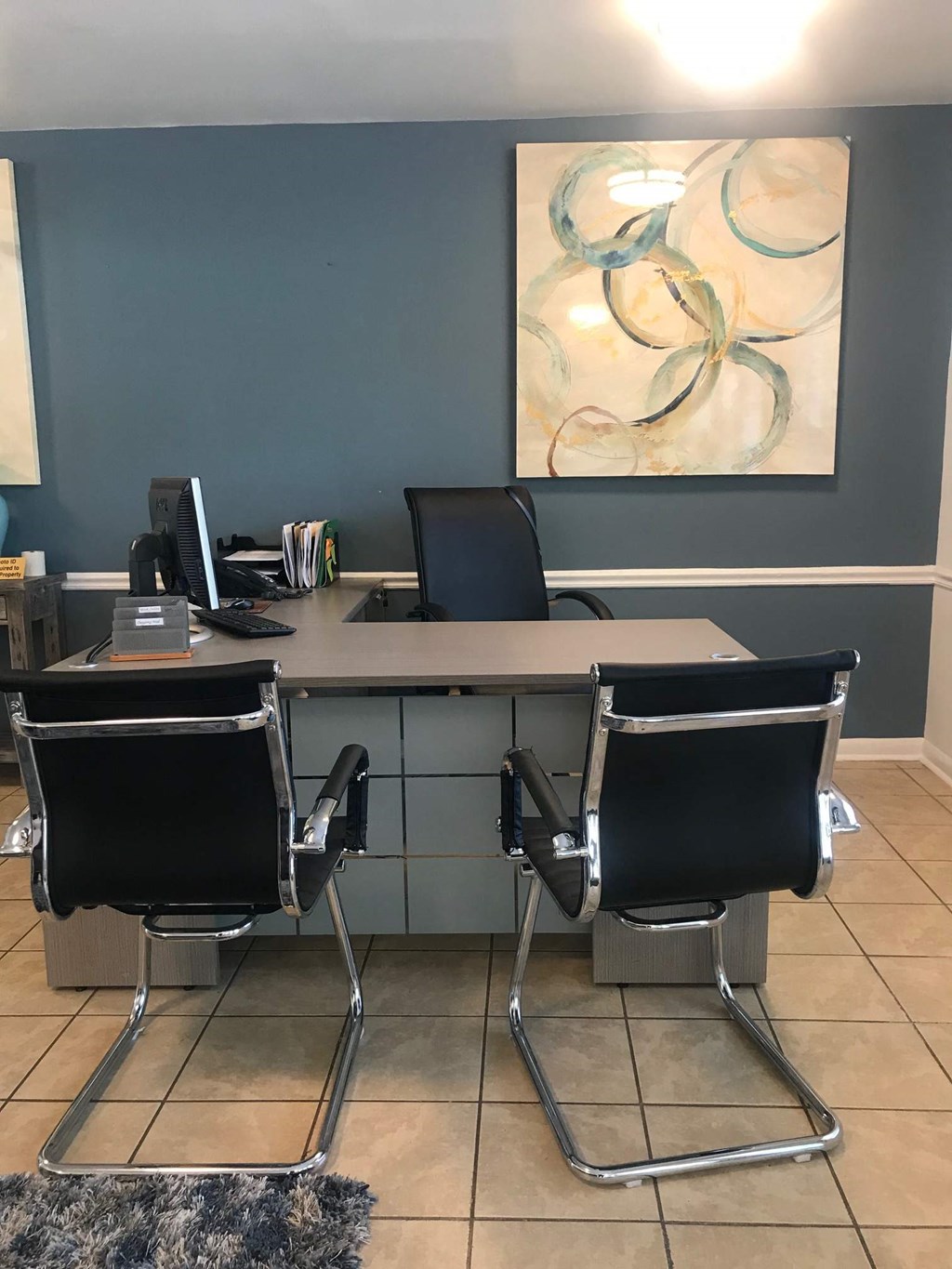 an office with a desk with chairs and a computer