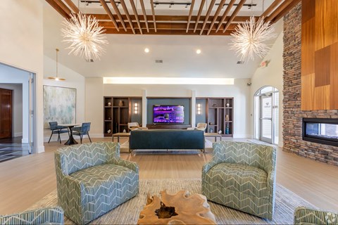 A living room with a stone fireplace and a television.