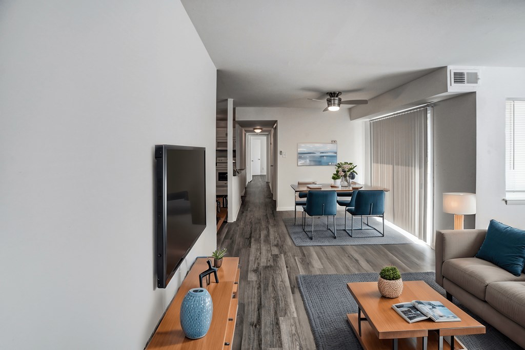 A living room with a blue vase on a wooden table.