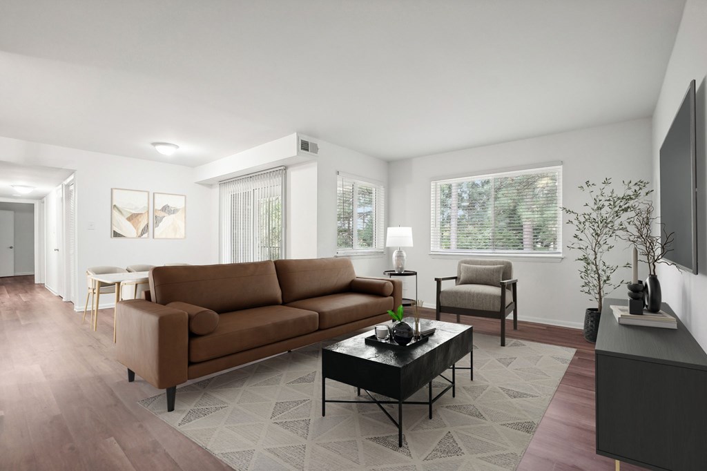 A living room with a brown couch, a coffee table, and a television.