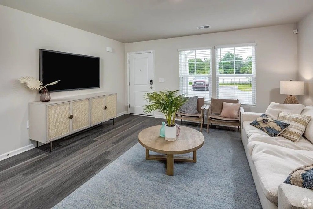 A living room with a flat screen TV mounted on the wall.