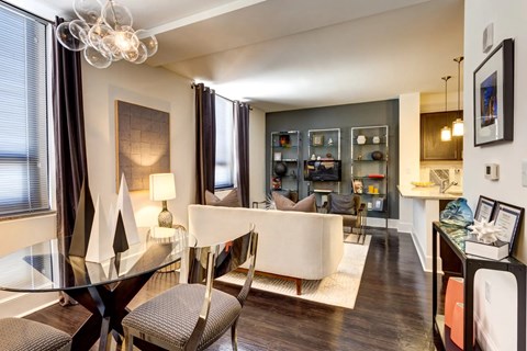 A modern living room with a glass dining table and chairs.