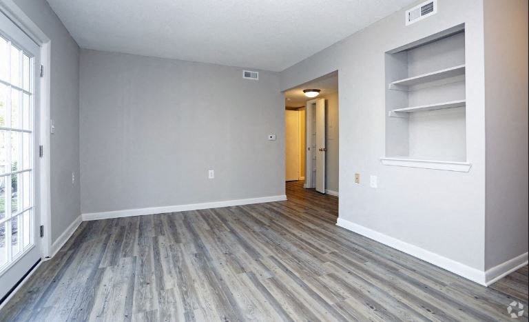 a empty living room with wood floors and white walls