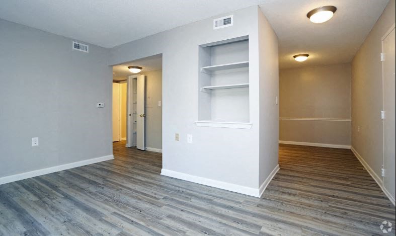 a empty living room with wood flooring and a closet