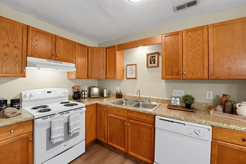 A kitchen with wooden cabinets and a white stove top oven.