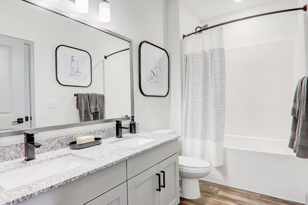 A bathroom with a toilet, sink, and shower curtain.
