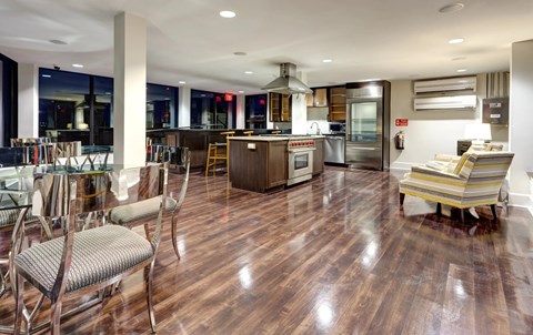 A modern kitchen with wooden floors and a dining area with chairs.