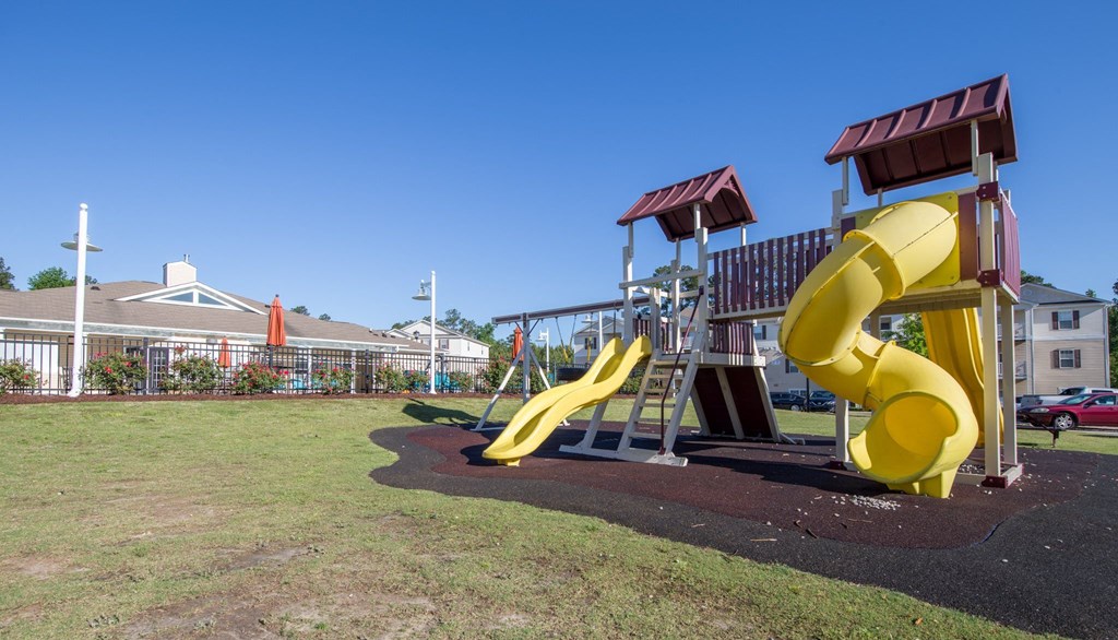 a playground with a large yellow slide and other playground equipment