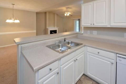A kitchen with white cabinets and a sink.