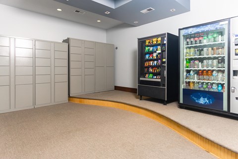 A room with a vending machine and a refrigerator.