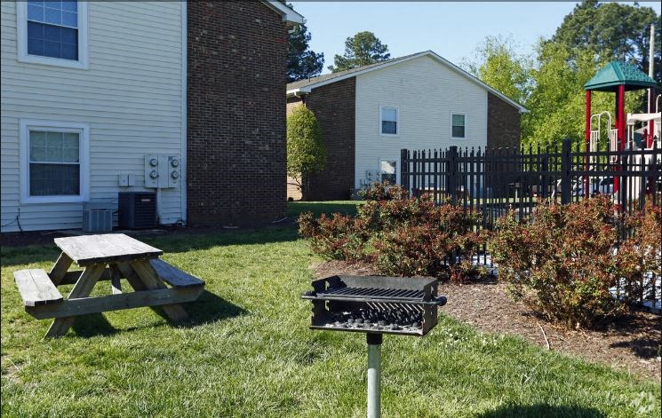 a backyard with a picnic table and a grill