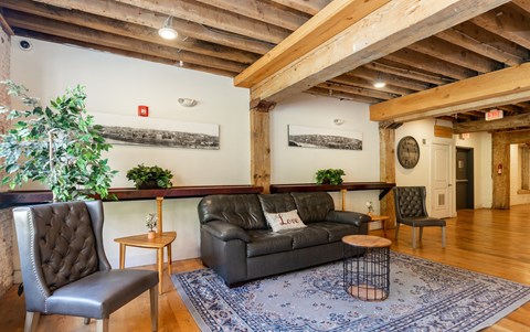 a living room with a leather couch and a rug