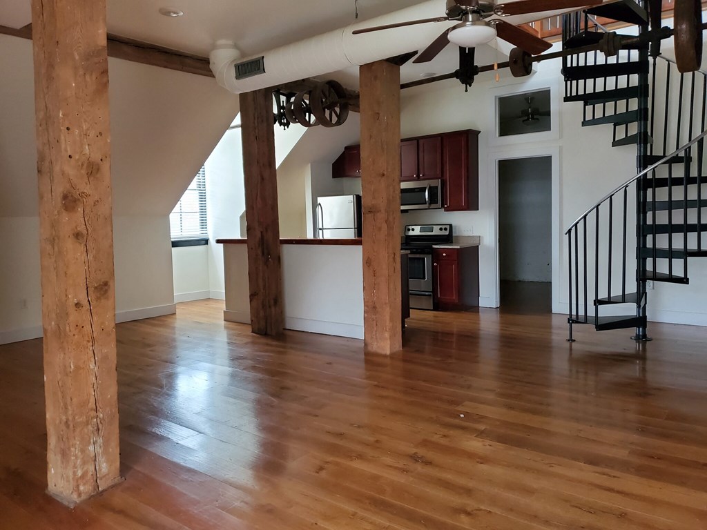 a view of a living room with wood floors and a staircase