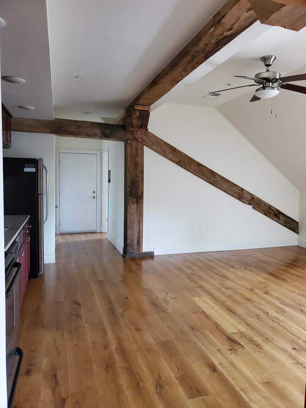 a living room with wooden floors and a ceiling with wooden beams