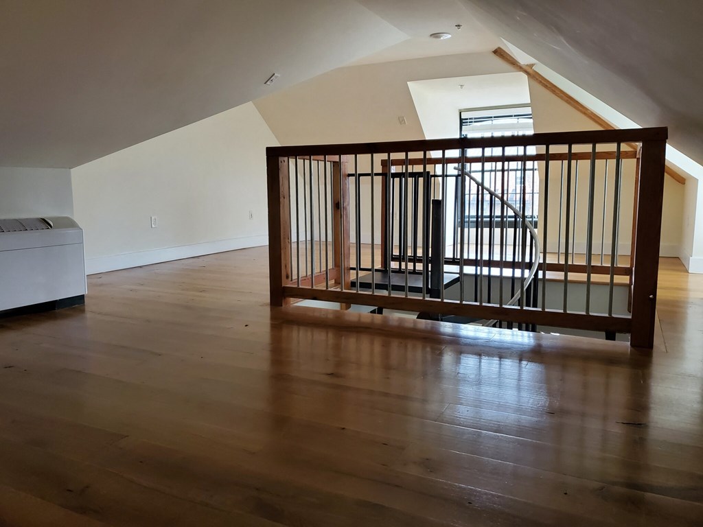 a living room with wood floors and a staircase