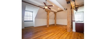 an open living room with exposed wood beams and a ceiling fan