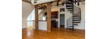 a living room with a staircase and a kitchen in a house