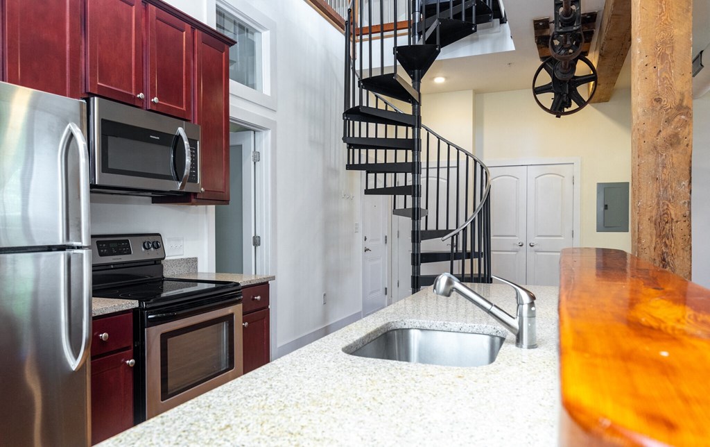 a kitchen with a sink and a spiral staircase