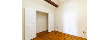 an empty room with white brick walls and a closet door
