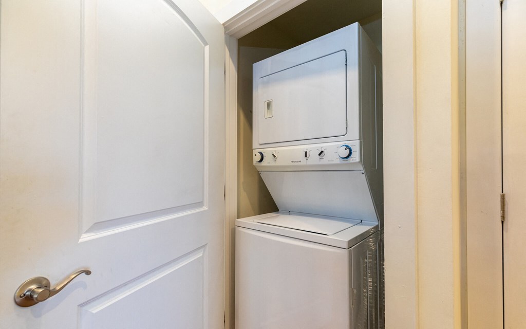 the laundry room has a washer and dryer and a door to the closet