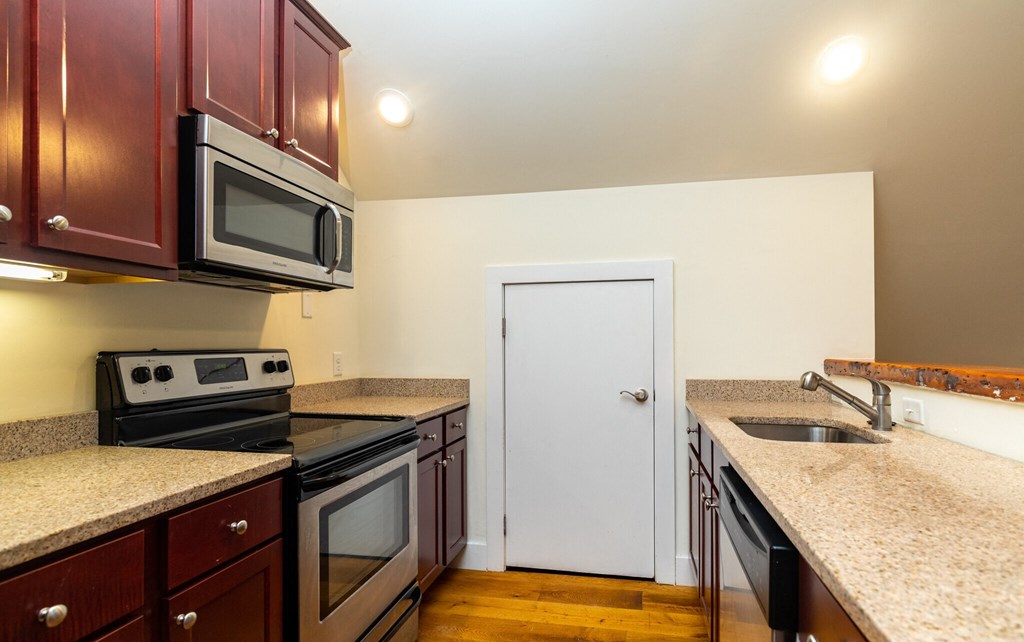 a kitchen with granite counter tops and stainless steel appliances