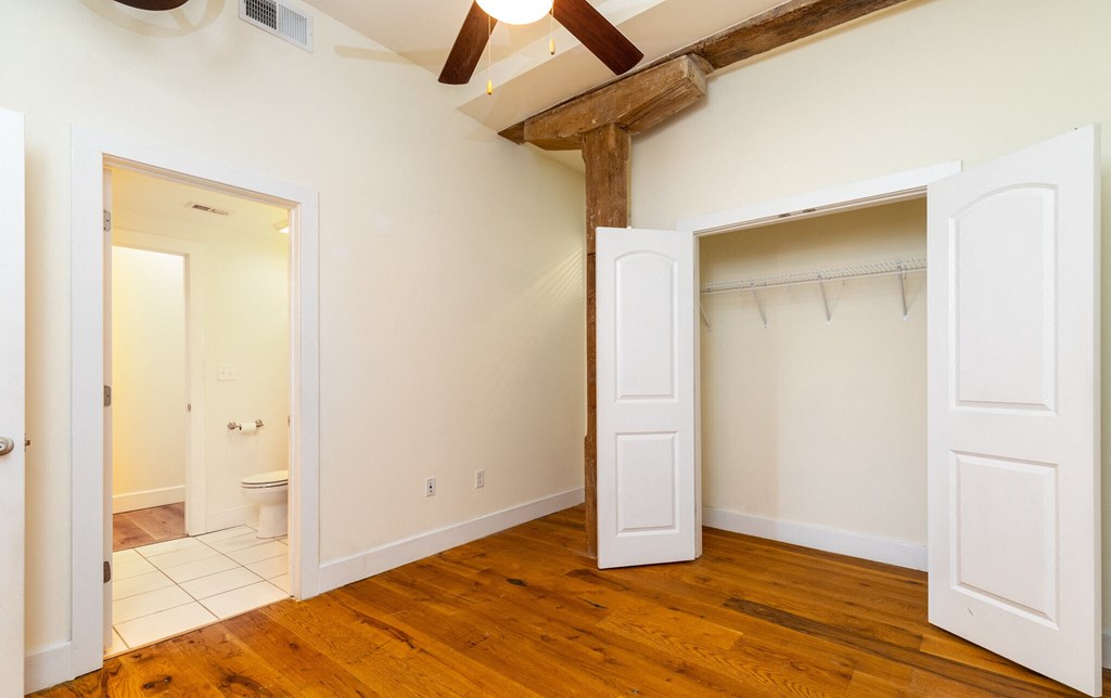 a living room with a wooden floor and a closet and a toilet