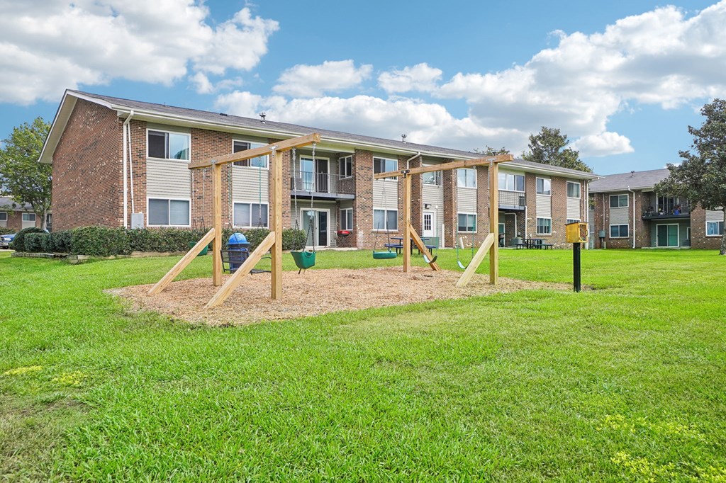 A playground in front of apartment buildings.