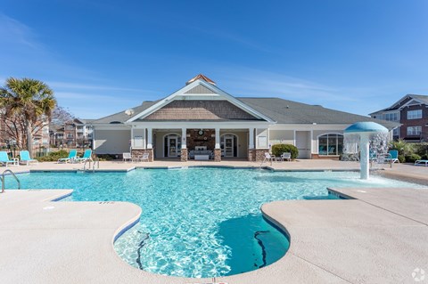 A house with a pool in front of it.