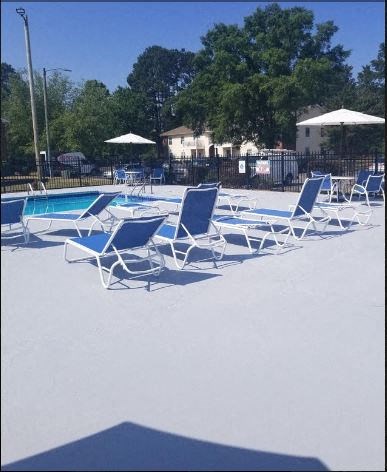 a group of blue and white chairs around a swimming pool