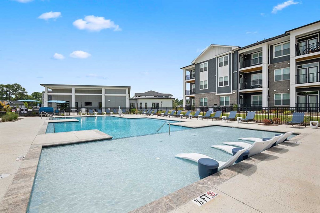 A swimming pool with a building in the background.