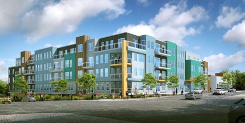 A modern multi-story building with a parking lot in front.