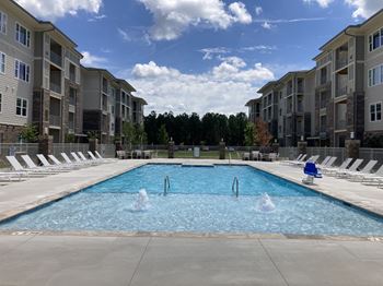 an apartment pool with water jets in front of an apartment building
