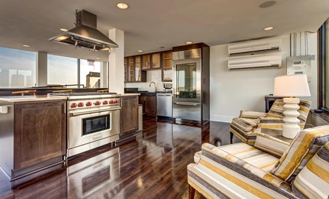 A modern kitchen with a striped couch and a stainless steel oven.
