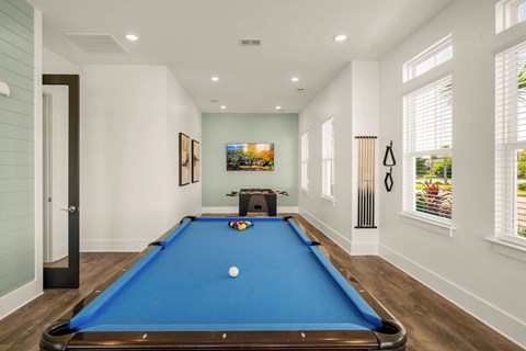 A pool table with a white ball in the middle of it.