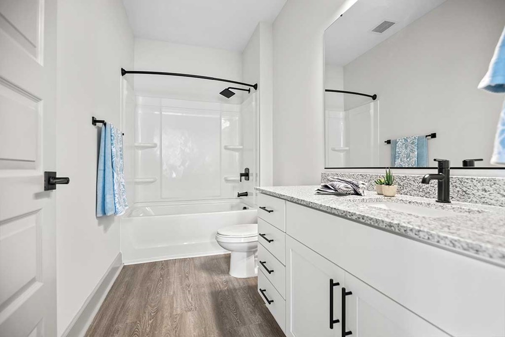 A bathroom with a white toilet, a sink, and a mirror.