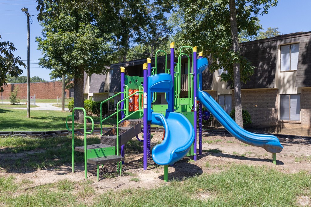 a playground in a park with slides and a bench