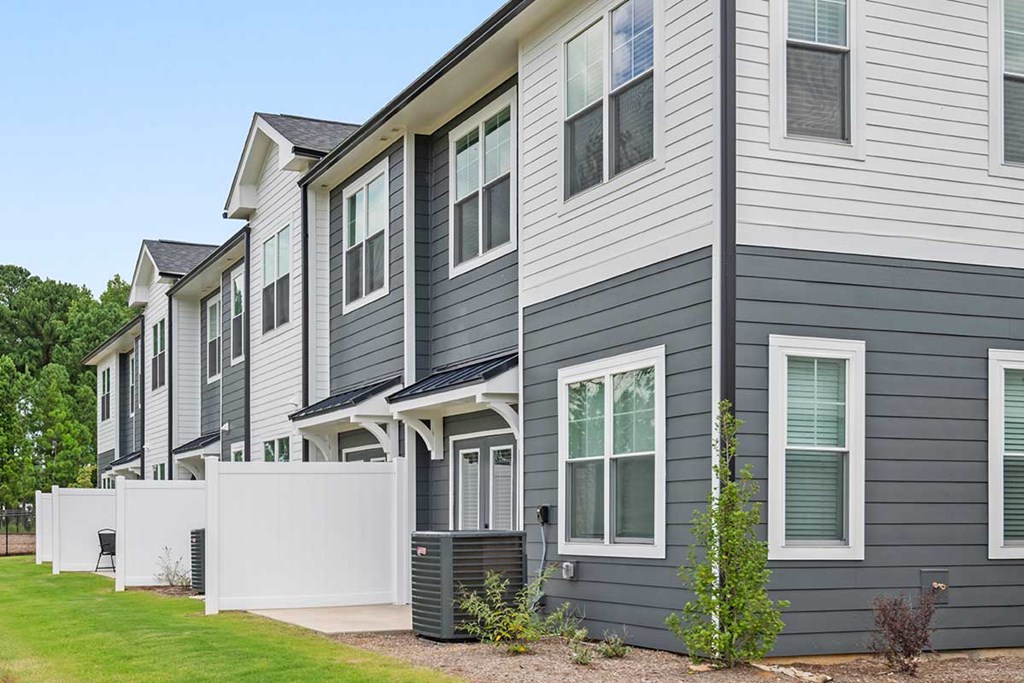 A row of houses with grey siding and white trim.