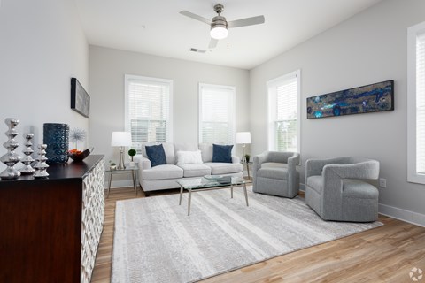 A living room with a white couch, a grey armchair, and a coffee table.