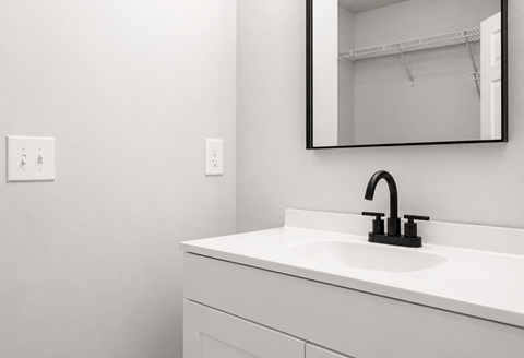 A white sink with a black faucet in a bathroom.