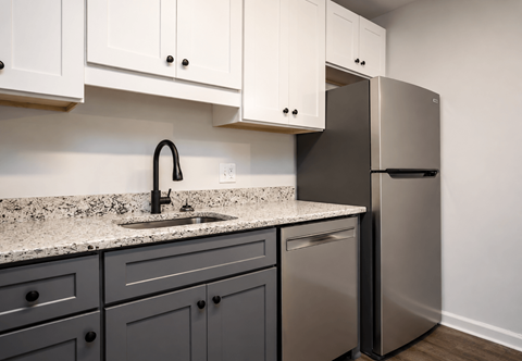 A kitchen with a sink and a refrigerator.